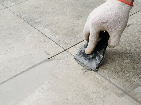 Flooring contractor applying grout to tile floors